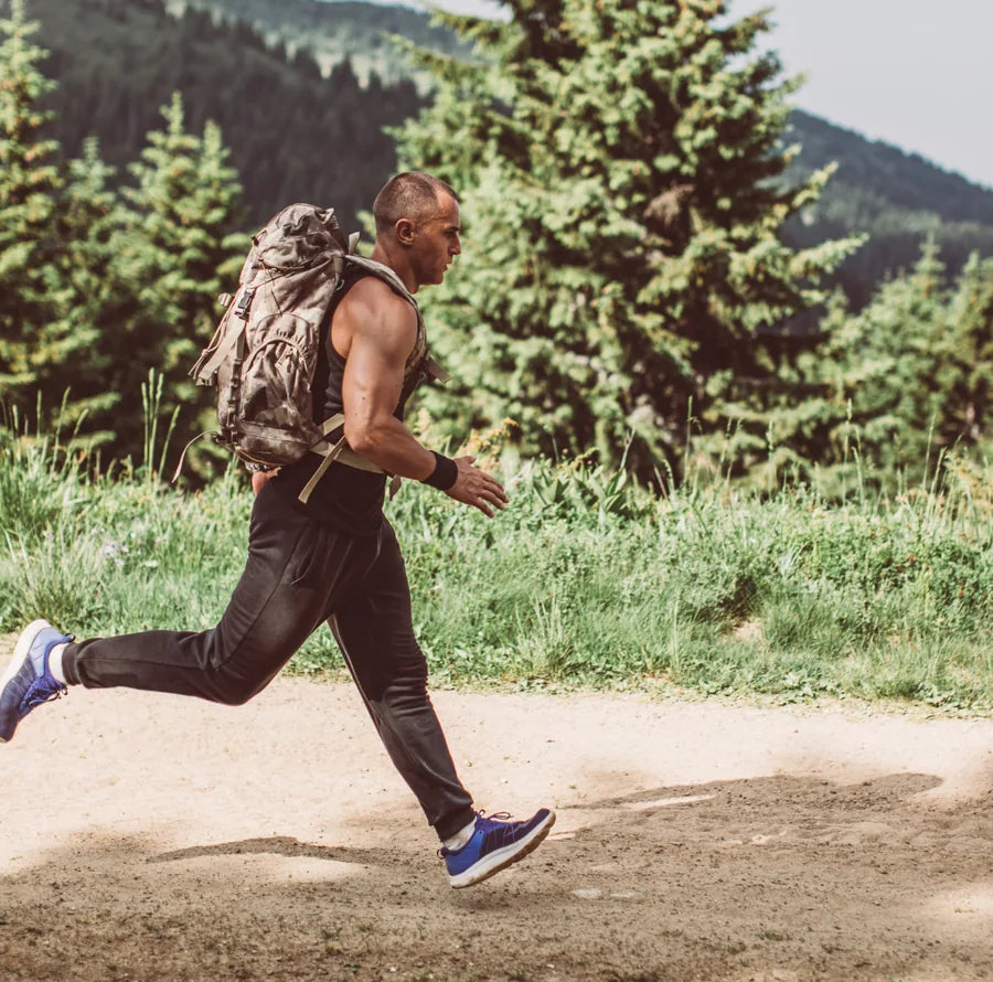 A man rucking with a weighted pack on a mountain trail